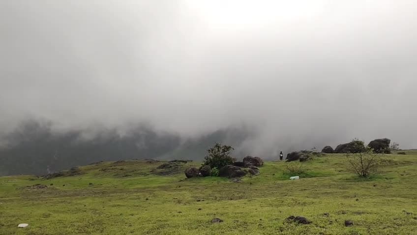 Low monsoon cloud moving across an open Sahyadri plateau.